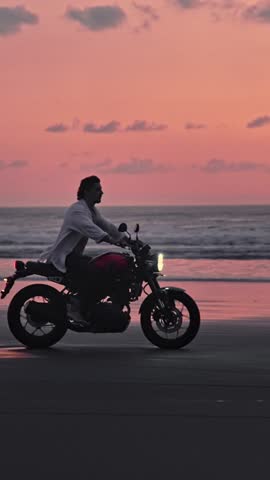 Man Riding Bike in Summer Landscape of Beach Traveling in Outdoors Nature. Handsome Motorcyclist or Surfer Driving Motorcycle in Speed Shot. Lifestyle of Alone Man in Motion on Stylish Transport