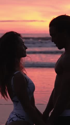 Lovely Couple Of Young Man And Happy Woman At Sea Beach Or Ocean Water. Romantic Lifestyle Of Surfing People In Swim Suits Bonding At Summertime Journey To Scenic Bay. Handsome Surfer Flirts With Lady