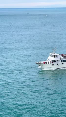 Tourist boat with passengers in bay of Porto Venere, Liguria. Tourists on sea transportation among mountains, rocks in Italy. Background for design. 
