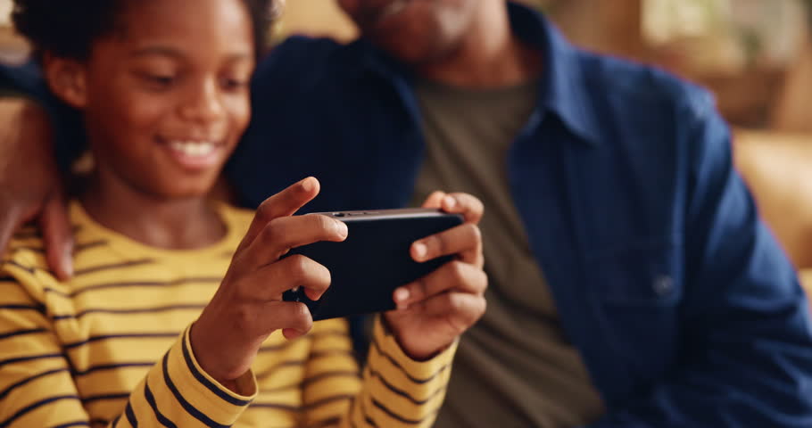 Black family, gaming or phone with father and son on sofa in living room of home for bonding or fun. Mobile game, love or smile with single parent man and child in apartment for app or challenge
