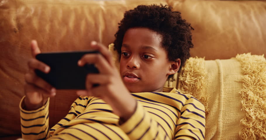 Couch, boy and black child with phone for games, connection or streaming cartoon movies in home. Entertainment, relax or kid gaming on sofa with mobile for watching video, playing online or addiction