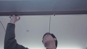 A young man looks upwards inside an airplane cabin, capturing a moment of reflection during travel. The setting highlights the unique experience of flying and the emotions it can evoke. - Powered by Shutterstock - Get 15% off with code: PIKWIZARD15