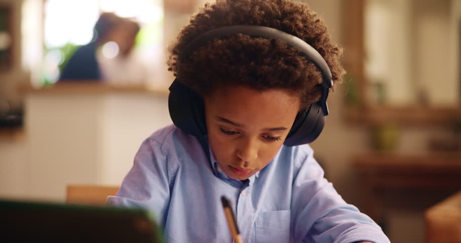 Boy, tablet and writing with headphones for elearning, virtual classroom or online lesson at home. African, young child or student with technology for distance learning, education or homeschooling
