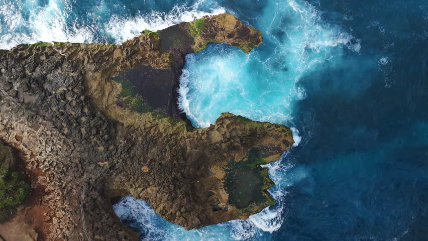 Ocean waves crashing on the rocks, top down above view