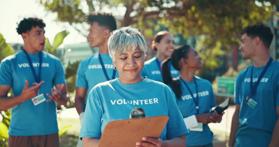 Clipboard, face and smile of volunteer group outdoor in community for charity or relief work. Checklist, donation and portrait of old woman with NGO team for non profit activism or welfare in park