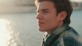 Young man looking thoughtfully across the Guadalquivir River in Seville, Spain, at golden hour. Slow-motion, close-up shot. - Powered by Shutterstock - Get 15% off with code: PIKWIZARD15