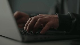 Close-up hands of unrecognizable programmer male typing on laptop keyboard, immersed in software development or coding, sitting at table by window in dark room. Concept of remote job, freelance. - Powered by Shutterstock - Get 15% off with code: PIKWIZARD15