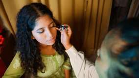 Makeup Artist Applies Eyeliner to Curly Haired Model, Gentle Black Strokes on Eyes Create Stunning Look, Young Woman Gets Styled in Beauty Studio, Beauticians Steady Hand Works on Soft Face Feature - Powered by Shutterstock - Get 15% off with code: PIKWIZARD15