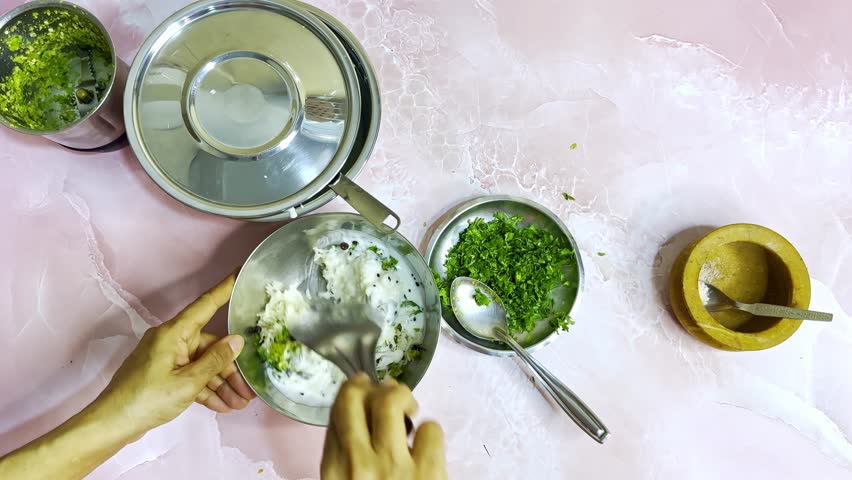 Spiced Curd Rice Hand Mixed in Traditional Indian Kitchen, Cooked Grains Blended with Yogurt and ingredient, Roasted seeds drop softly into white mixture, Powdered scatters evenly across creamy dish