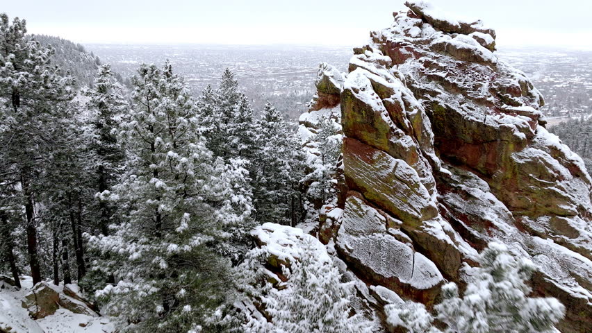 Snow-covered mountain rocks and forest landscape in winter