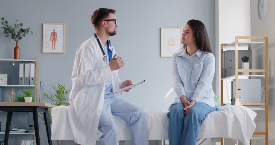 Smiling doctor or nurse consulting a patient during a hospital visit. Medical consultation involves talking and providing advice, ensuring the patient receives the care and information during visit.
