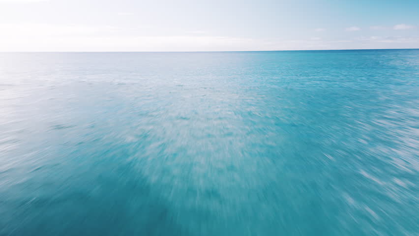 Low altitude flight over the sea. Camera flights fast over the ocean's surface with naturally blurred water surface.