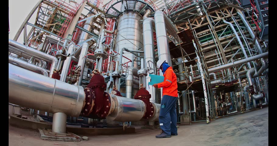 Male worker inspection at steel long pipes insulation and pipe elbow in station oil factory during refinery valve of visual check record pipeline tank oil and gas
