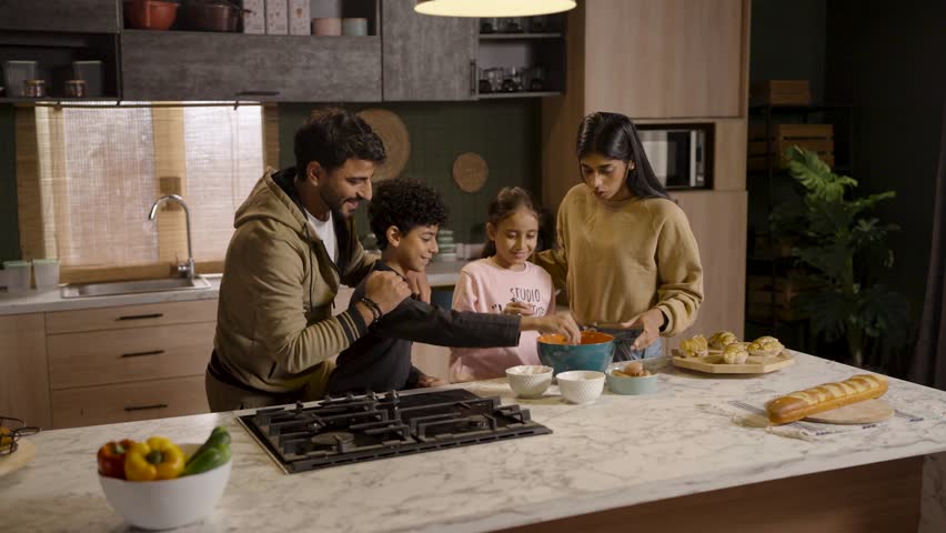 A happy family enjoys cooking together in the kitchen, sharing laughter and creating delicious memories.
