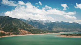 Mountains and lake video timelapse for background. Panorama of reservoir Charvak, lake in mountains. Taken from top of small Chimgan. Heavy cumulus clouds fly over turquoise surface of water. - Powered by Shutterstock - Get 15% off with code: PIKWIZARD15