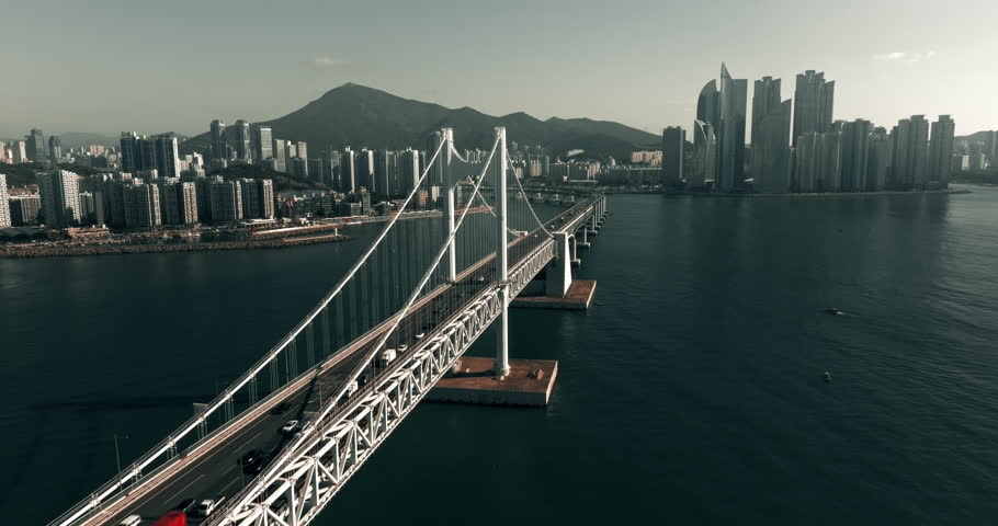 Aerial view of traffic on Gwangan bridge with Busan skyline in the background in South Korea during morning with clear sky