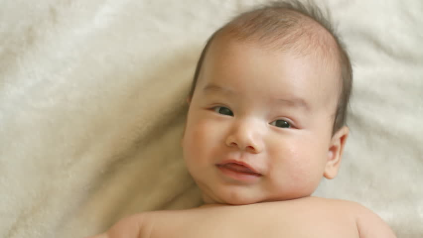 Close up of a happy three month old, Asian-American baby boy wriggling around