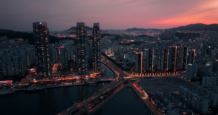 Aerial drone view of traffic and Busan skyline during a dramatic sunset, South Korea