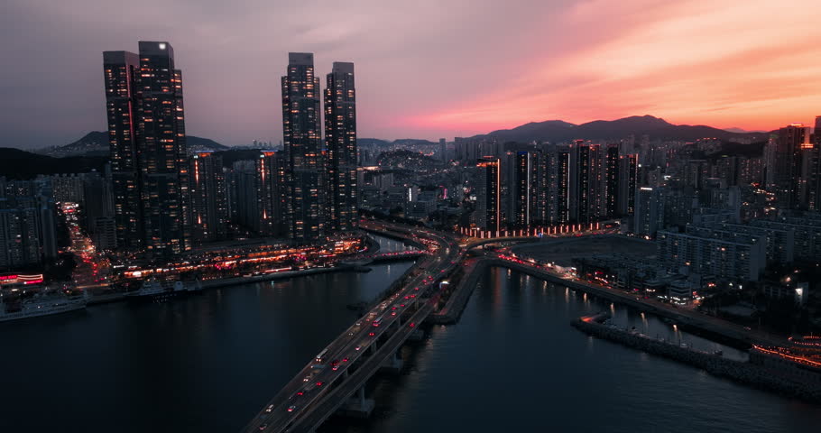 Aerial drone view of traffic and Busan skyline during a dramatic sunset, South Korea