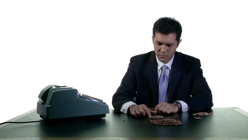 Business man in white studio counting up beans and entering the numbers on a
