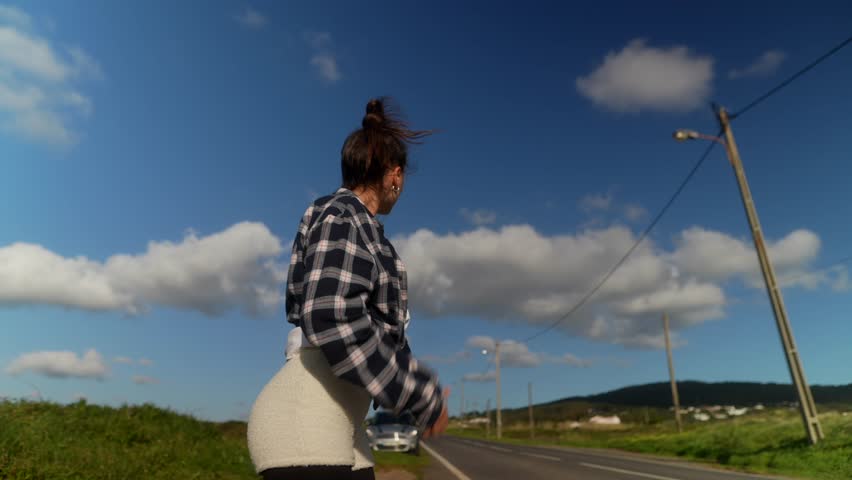 A Young Woman Happily Hitchhiking on an Idyllic and Beautiful Day Filled with Sunshine