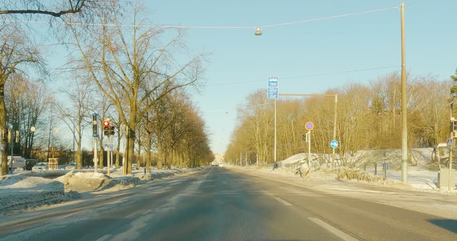 POV view from car driving on Mäkelänkatu street in cloudy winter weather with snow on the ground, Helsinki, Finland.