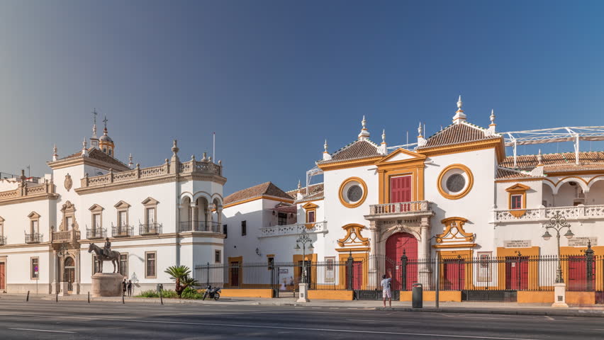 Plaza de Toros de la Real Maestranza de Caballeria de Sevilla timelapse hyperlapse. Traffic passing in front of its facade. Historic bullring in Seville, Spain, known for its bullfighting festivals.