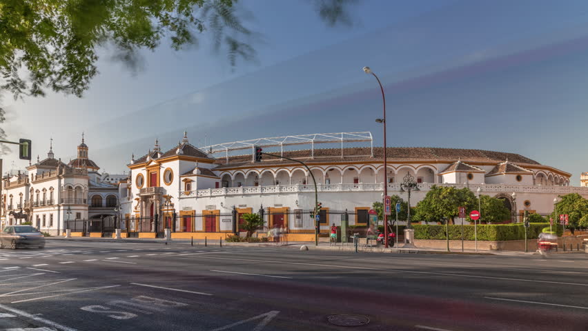 Plaza de Toros de la Real Maestranza de Caballeria de Sevilla timelapse hyperlapse. Historic bullring in Seville, Spain, known for its bullfighting festivals. Traffic passing in front of its facade