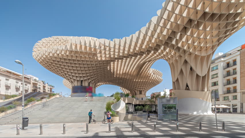Metropol Parasol in Encarnacion Square timelapse hyperlapse, futuristic wooden structure with panoramic walkway and an archaeological museum. Blue sky, stairs, traffic and cityscape in Seville, Spain