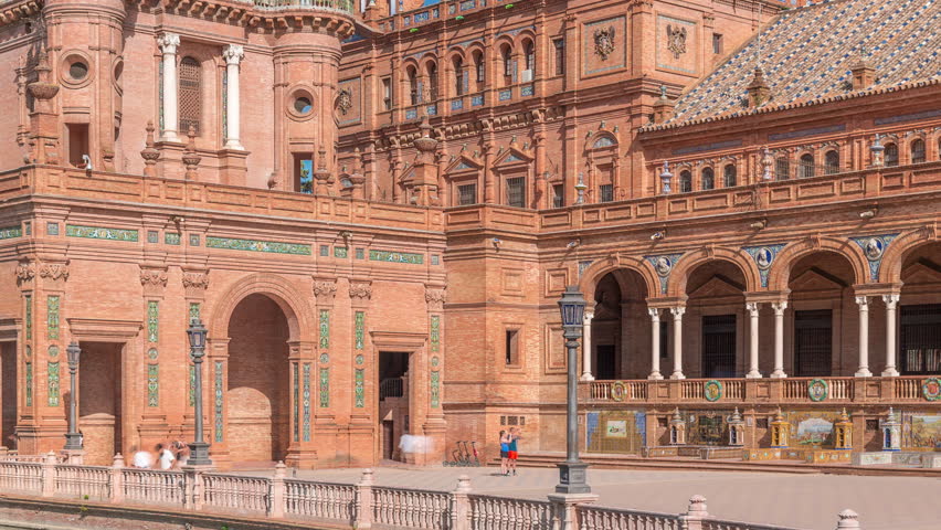 Plaza de Espana in Seville timelapse, a grand architectural complex in Maria Luisa Park built for the Ibero-American Exposition. Arches, canal and red walls under blue cloudy sky.