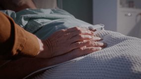 Wife strokes hand of sick elderly husband lying on hospital bed closeup. Mature woman cares about beloved partner recovering in modern medical ward - Powered by Shutterstock - Get 15% off with code: PIKWIZARD15