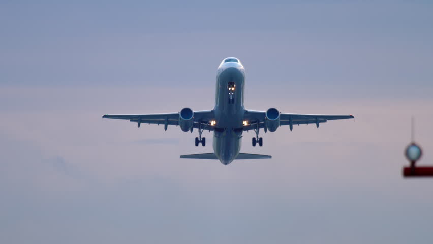 Jet airplane aircraft taking off overhead and retracting landing gear