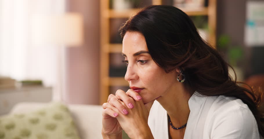 Stress, thinking and woman in home for decision, reflection and planning for solution. Thoughts, unhappy and sad person with challenge in living room, doubt or remember serious memory with vision