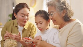 Happy Asian three generation women family enjoy weekend activities lifestyle knitting in living room. Family relationship spending time together at home. Senior person mental health and healthcare. - Powered by Shutterstock - Get 15% off with code: PIKWIZARD15