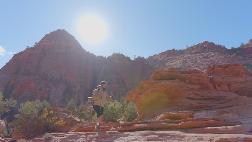 African American male embarks on a hike in Zion National Park, surrounded by stunning red rock formations and vibrant landscapes under a beautiful sky, embracing natures adventure