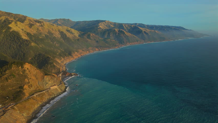Stunning aerial shot captures the surreal beauty of Big Sur along Californias Highway 1 at sunset, showcasing the dramatic coastlines and serene ocean views that define the region
