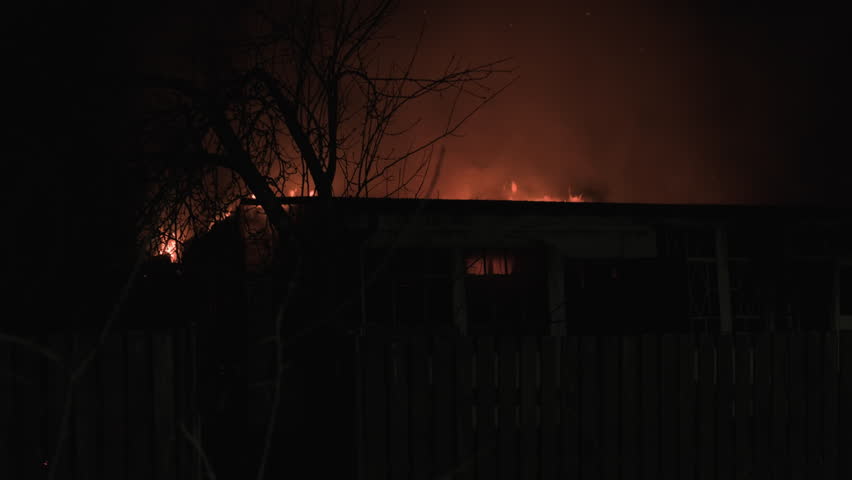 Burning wooden house on fire at night