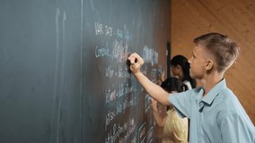 Site view of boy writing code on blackboard with diverse friend. Group of high school children using mind map to explain planing coding or programming system in STEM technology class. Edification - Powered by Shutterstock - Get 15% off with code: PIKWIZARD15