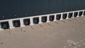 Aerial view of logistics warehouse exterior with loading platforms. Truck bays at distribution center with closed loading gates. Commercial infrastructure for freight operations - Powered by Shutterstock - Get 15% off with code: PIKWIZARD15