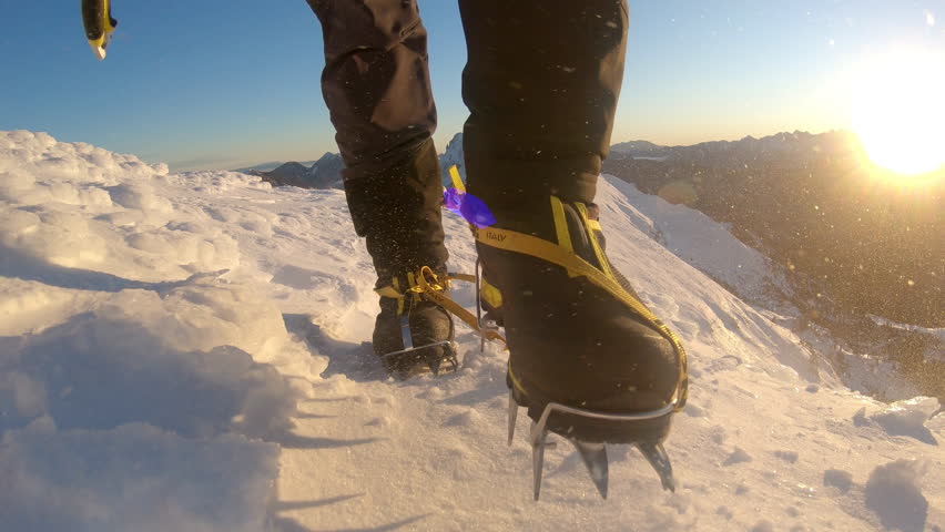 Climber's crampons dig into the snow, highlighting the thrill and challenge of mountaineering. The close-up shot conveys determination and the beauty of nature.