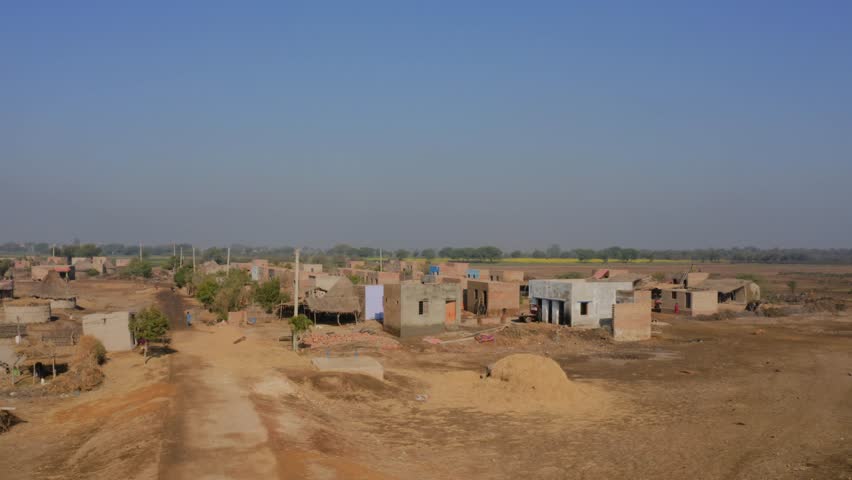 Drone shot featuring rural village near Sukkur in Sindh, Pakistan on sunny day.