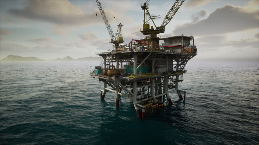 An old oil rig platform extracting oil from the ocean, surrounded by water under a clear sky.