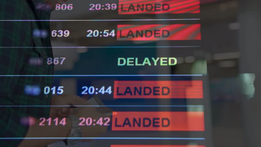 Flights delayed and canceled on departure board, flight delay footage. Device screen with airport flight information