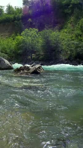 People in Rafting Boat Descending Mountain River. People in Inflatable rafts paddling through river rapids. Active vacations. Stress-relieving activity in nature. Active outdoor Pursuit.