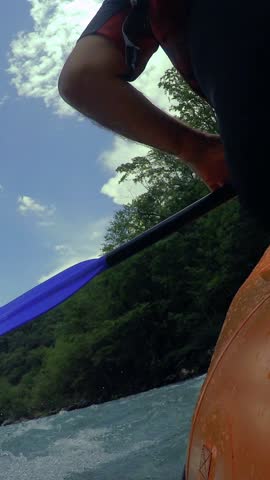 Whitewater Rafting Adventure - POV. Paddling in River Rapids. Rafting team descending raging rapids. Active vacations. Active outdoor pursuit. Mountain river canyon with people in rafting boat.