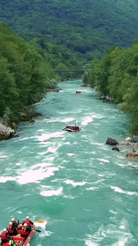 Whitewater Rafting Adventure - Aerial View. People in inflatable rafts paddling through river rapids. Drone POV of picturesque mountain river canyon. Active Vacations. Active outdoor Pursuit.
