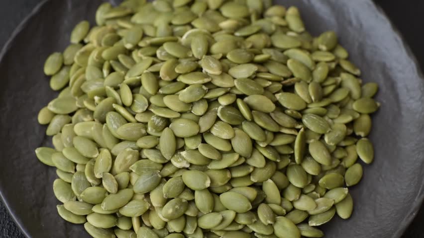 Peeled pumpkin seeds in a bowl, an ingredient for making vegan or vegetarian food. Tasty and healthy food