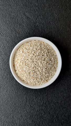 White sesame seeds in a bowl, an ingredient for making vegan or vegetarian food. Tasty and healthy food