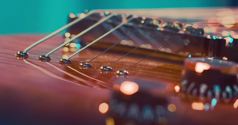 Close-Up of an Electric Guitar. Details of strings, frets, and the body shine under moody lighting. Music, creativity, and rock culture.