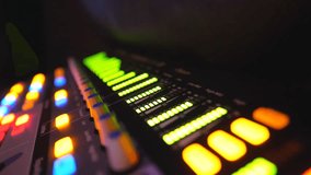 Close up of soundboard with knobs and green color equalizer in night club. View on audio waves or music control levels at professional sound equipment. Slow motion - Powered by Shutterstock - Get 15% off with code: PIKWIZARD15
